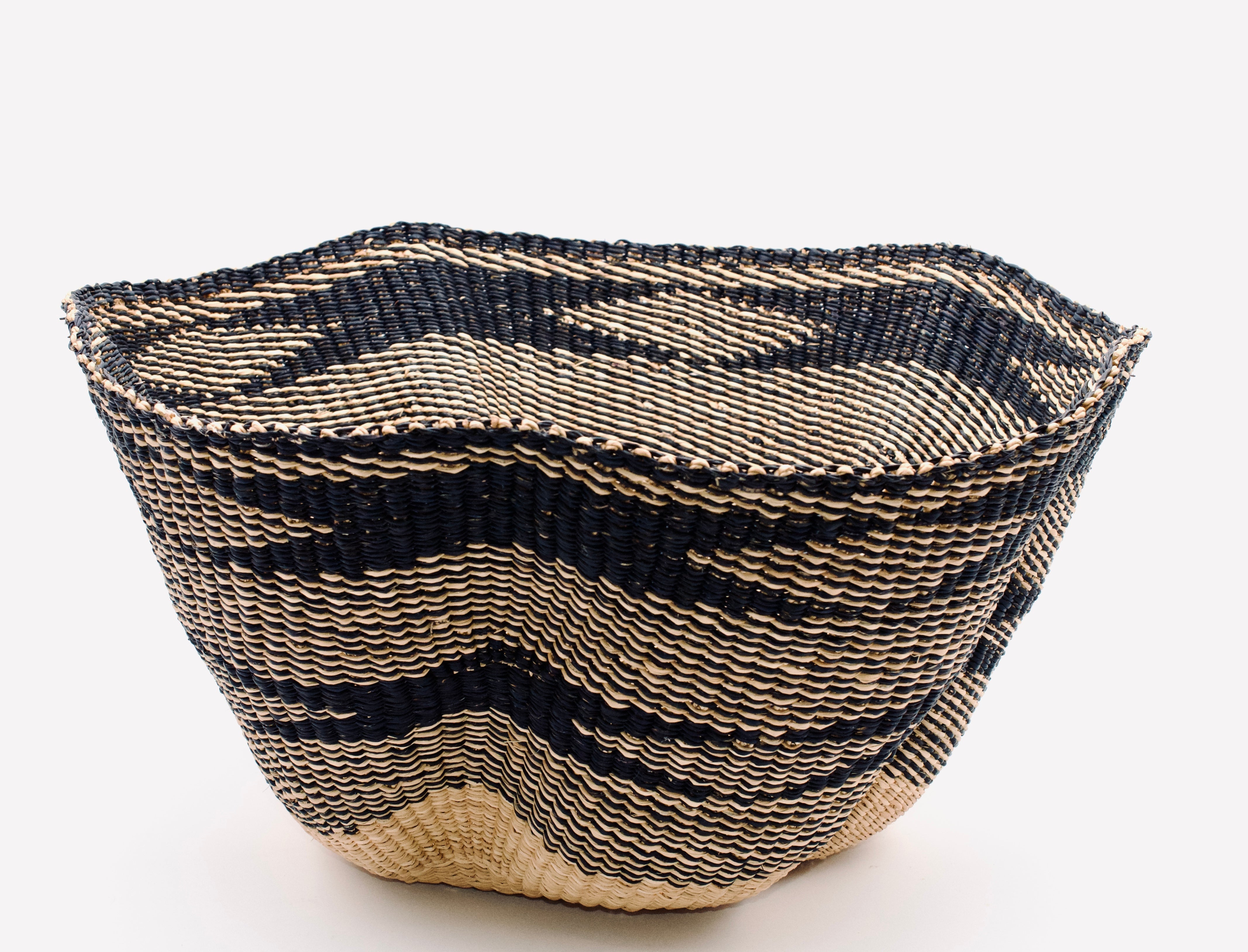 Woven basket with black and beige pattern on a white background